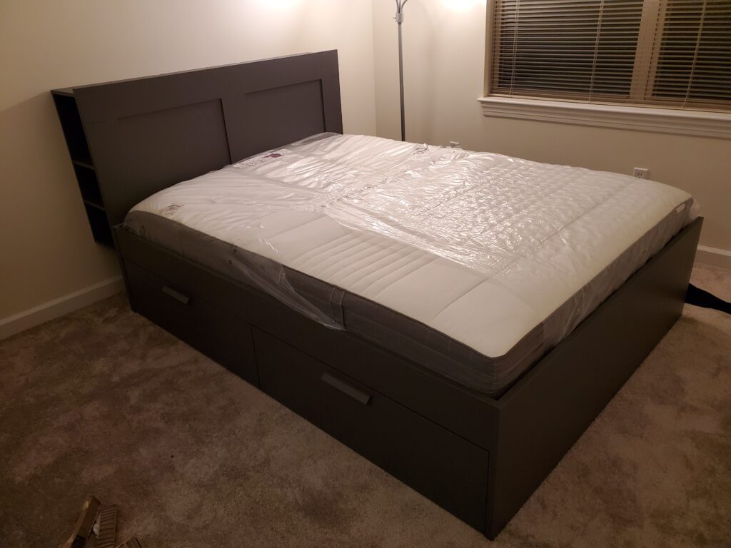 Dark storage bed with drawers assembled in a bedroom
