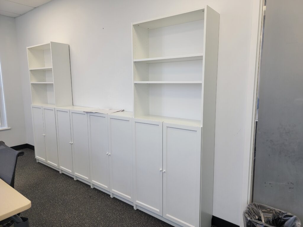 White office cabinets and bookshelves assembled along a wall