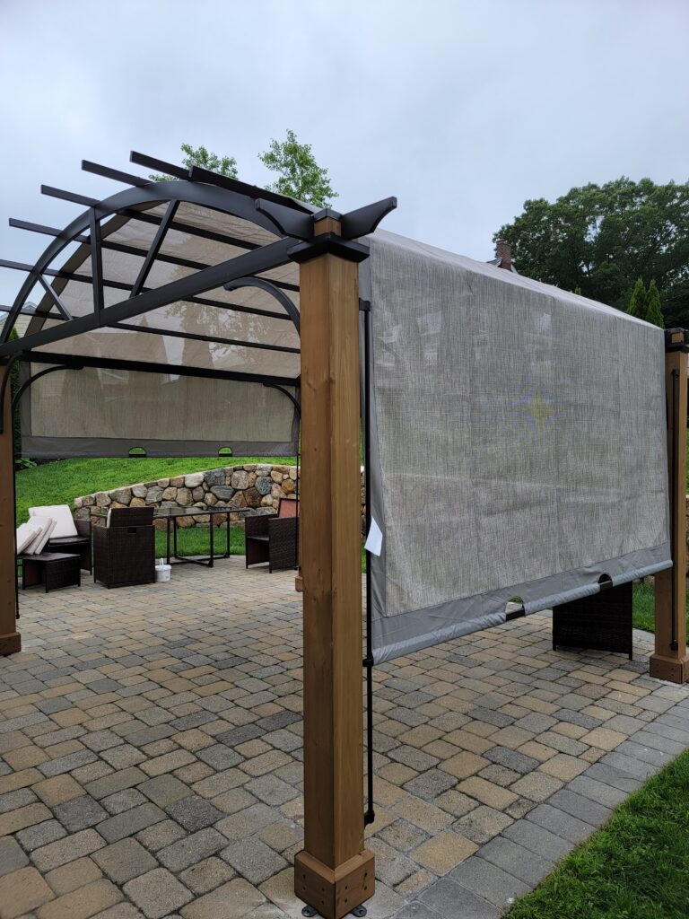 Pergola with a shade canopy assembled over a paver patio