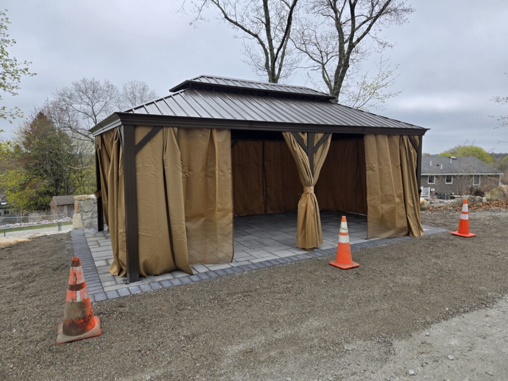 Hardtop gazebo with curtains assembled on a new patio